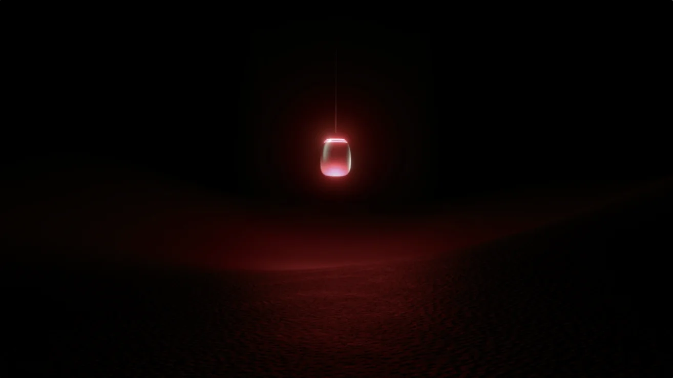 A single red lightbulb hangs in a dark space, casting a soft red glow below.